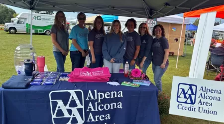 AAACU Team members pose with bags of trash they cleaned up in the community.